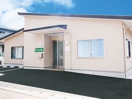 白色の外壁が明るい印象を与える、平屋建ての施設外観