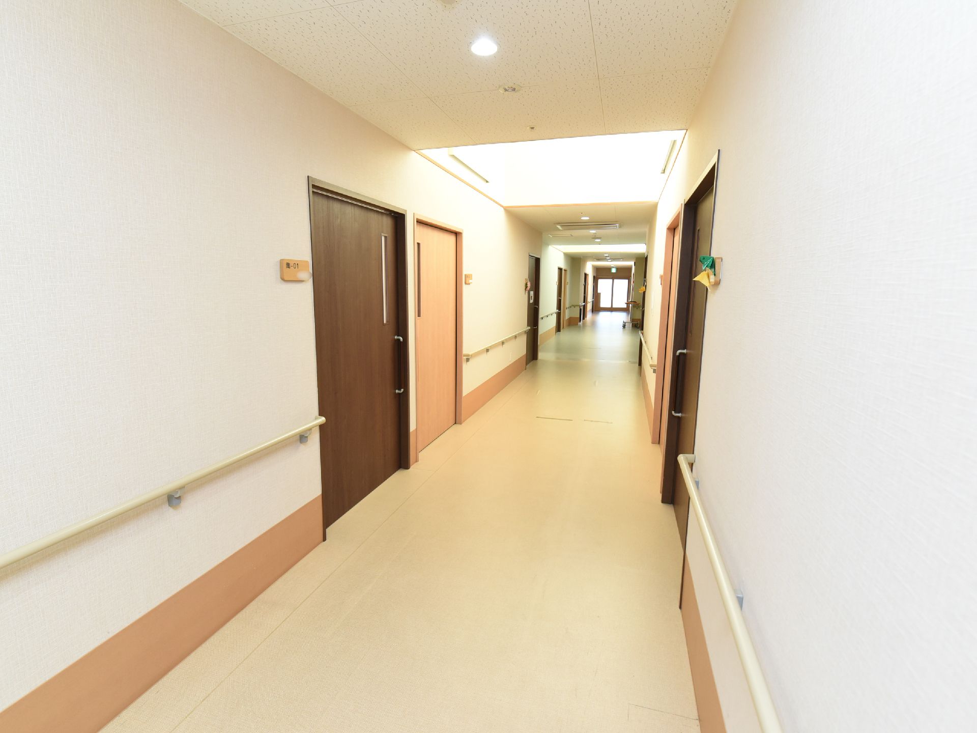 各居室のスライド式のドアの横に部屋番号が貼られている。天井に丸型のライトと火災報知器が設置されている。