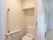 白いスライド式のドアを開けるとトイレが設置されている。高いところには収納扉もある。壁には緊急用の呼び出しボタンもついている。