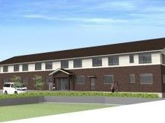 ダークブラウンと白のツートーンカラーの外壁に、ダークブラウンの三角屋根がのっている２階建ての建物である。