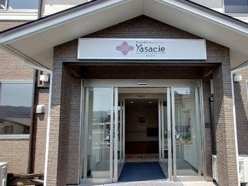 自動ドアが二重についている施設の入り口。入口の上にはロゴマークの入った施設名の看板が掲げられている。