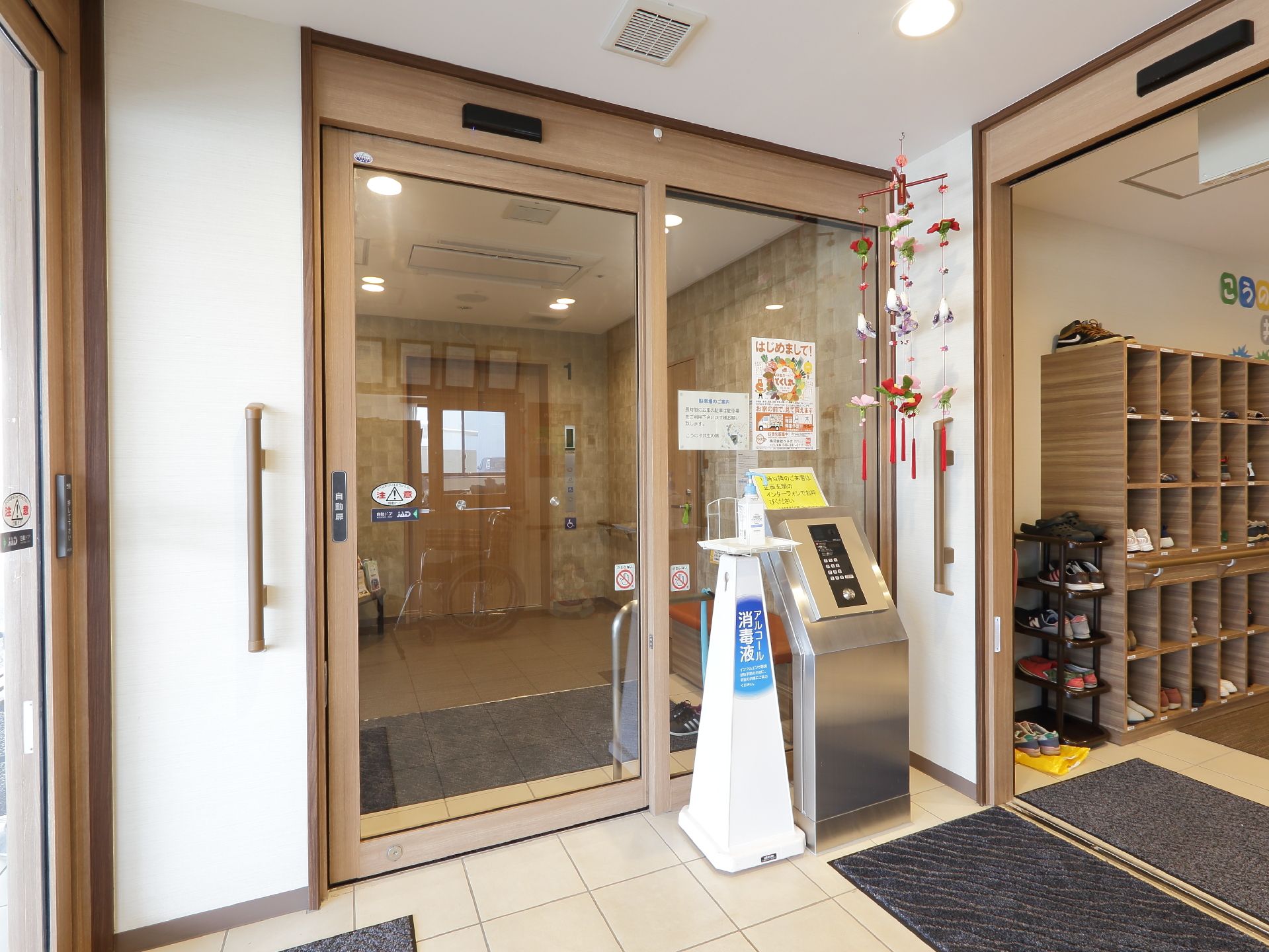 風除室内の様子。目立つ金属製のオートロックのコントローラーが設置され、その隣には消毒用アルコールが置かれている。