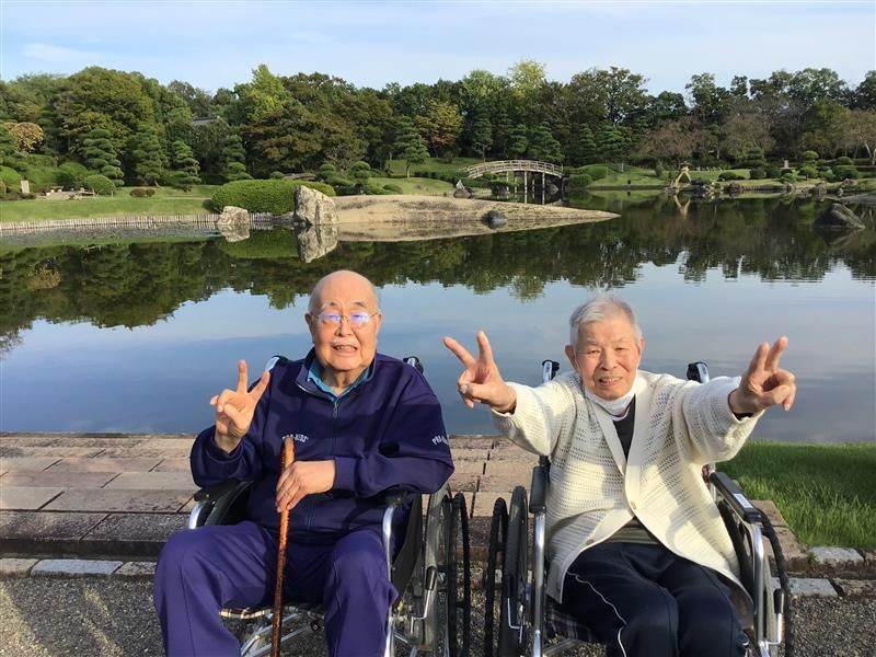 笑顔のご高齢者二人と庭園
