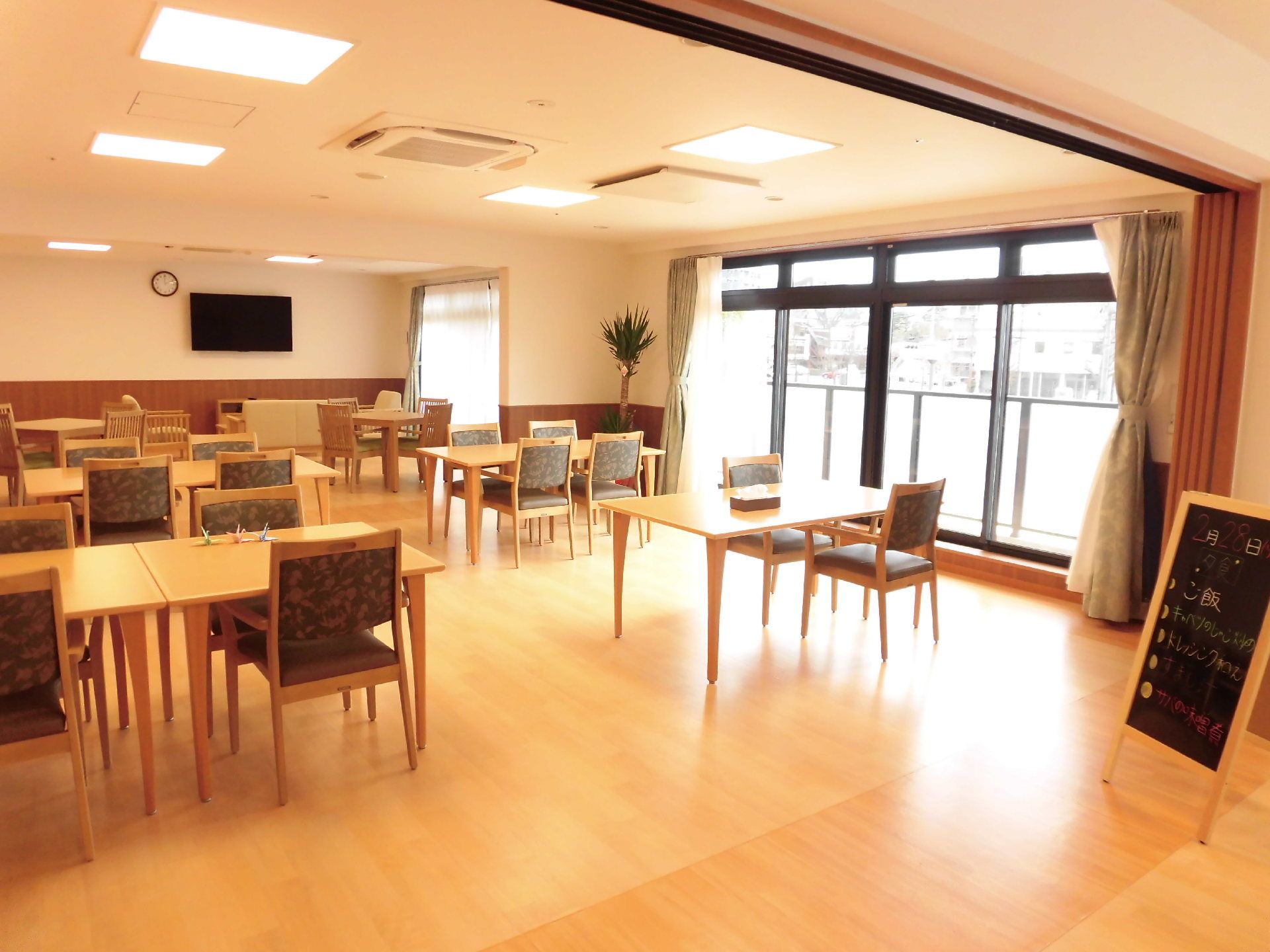 広々としたリビングには椅子やテーブルが並んでおり、入居者様が集う場所である。各種イベントなどを開催している。