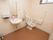 広い個室内に、洋式トイレと手洗い場がある。壁にL字型の手すりと呼出ボタンがある。洗面ボウルの壁に鏡が付いている。
