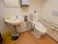 洋式トイレの横には鏡が付いた手洗いが設置されている。石鹸やペーパータオルが用意されている。周囲の壁には手すりが取り付けられている。