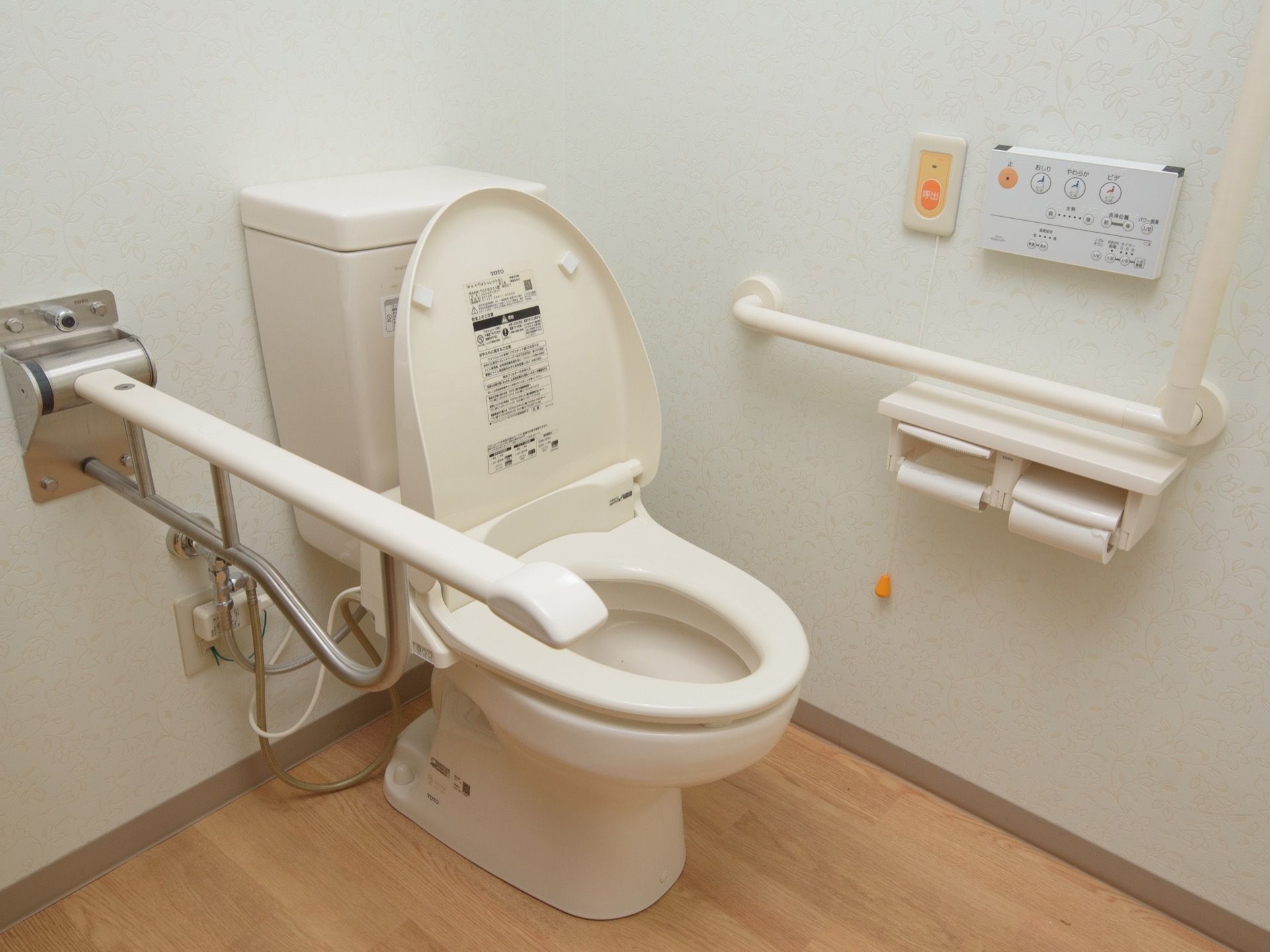 トイレは便器の両脇に手すりが設置されている。左手の壁には２つのペーパーホルダーとトイレの操作パネル、緊急呼出ボタンが取り付けられている。