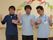 施設の男性スタッフが３人、カメラに向かっておどけたポーズと表情をつくっている。身動きしやすいポロシャツの制服を身につけている。