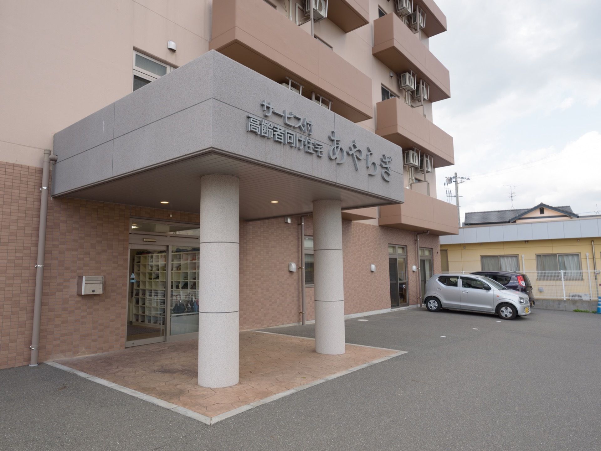 駐車場から玄関までが近いので移動が楽である。落ち着いた色をした玄関はとても広い。さらに、入口の上部には屋根が設置され、扉は自動ドアである。