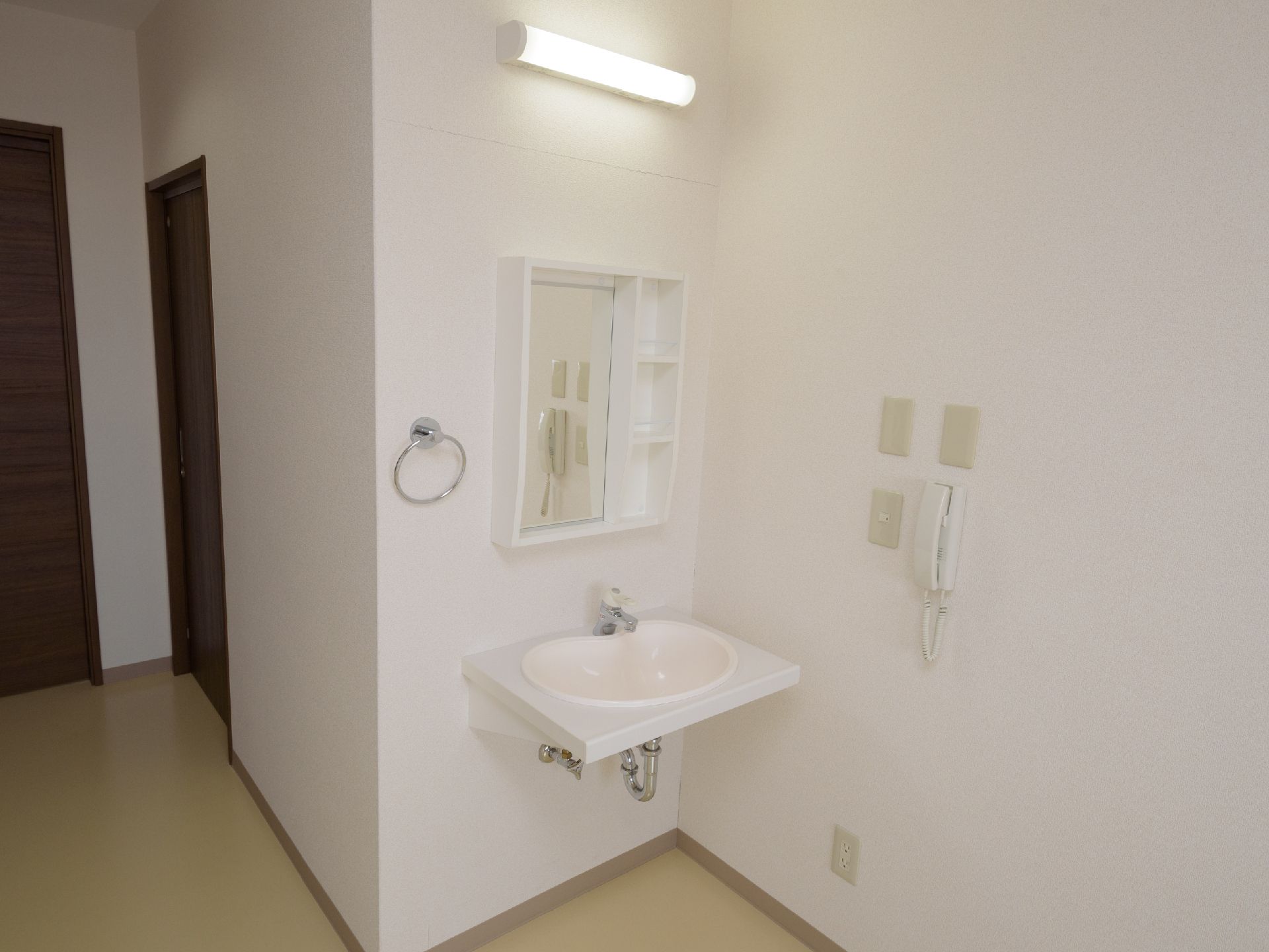 レバー引き上げ式の水栓がついた洗面台が設置されている居室