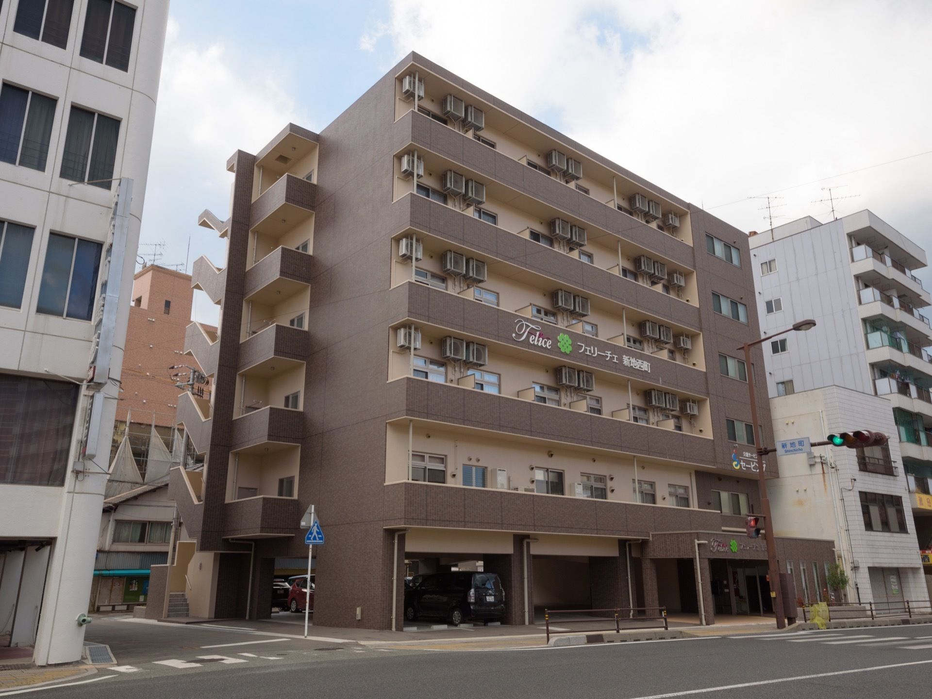 施設感を感じない一般のマンションのような外観。外壁は落ち着いた２色使いで、１階に駐車場がある６階建ての建物である。