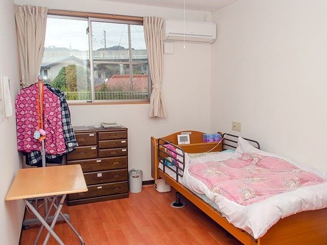 明るい木目調の床を採用した、生活感あふれる居室である。窓の横にエアコン設置されており、真夏や真冬も快適な温度で過ごせる。