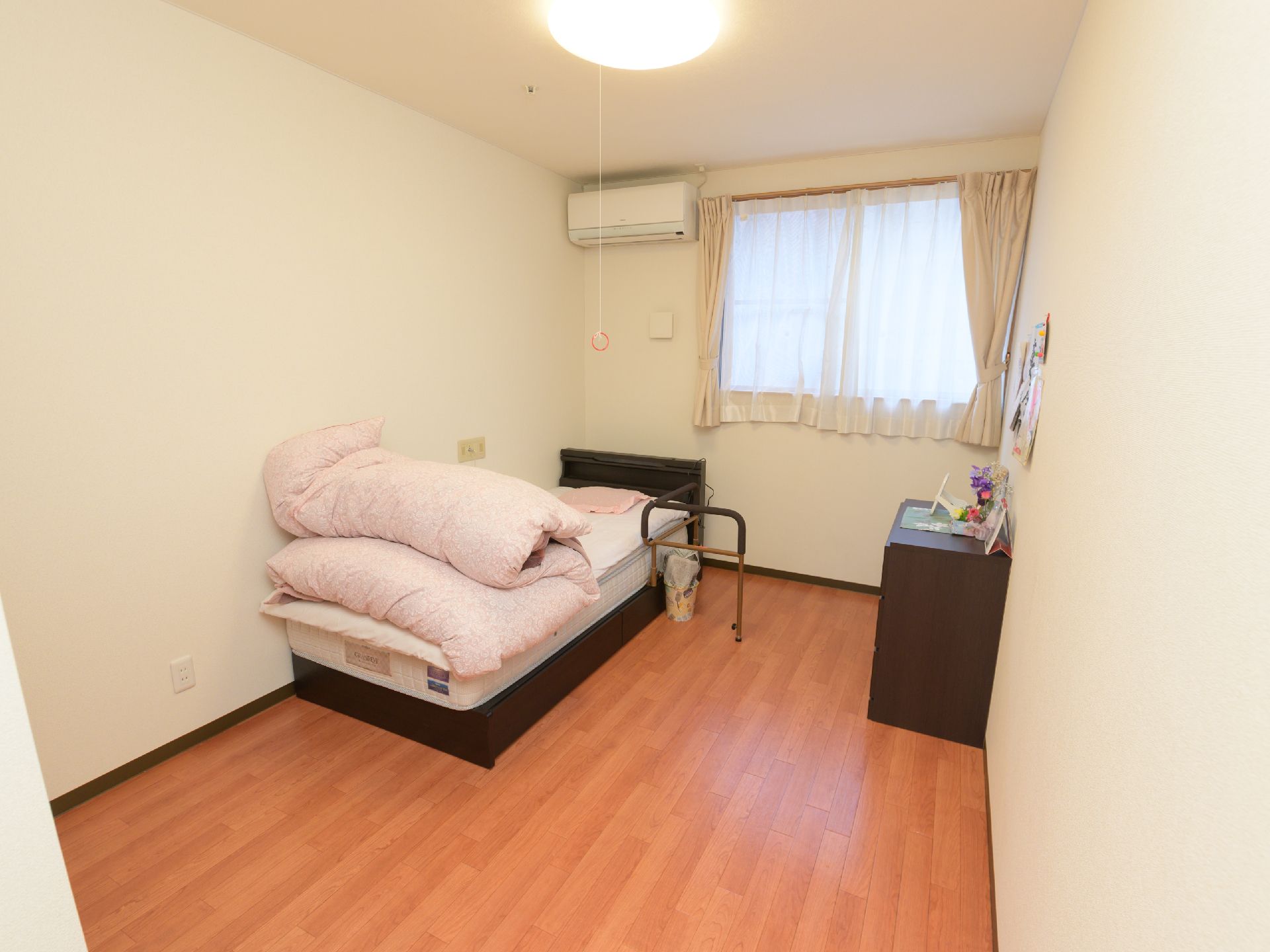 可動式の手すりがついたベッドが置かれている、すっきりとした居室