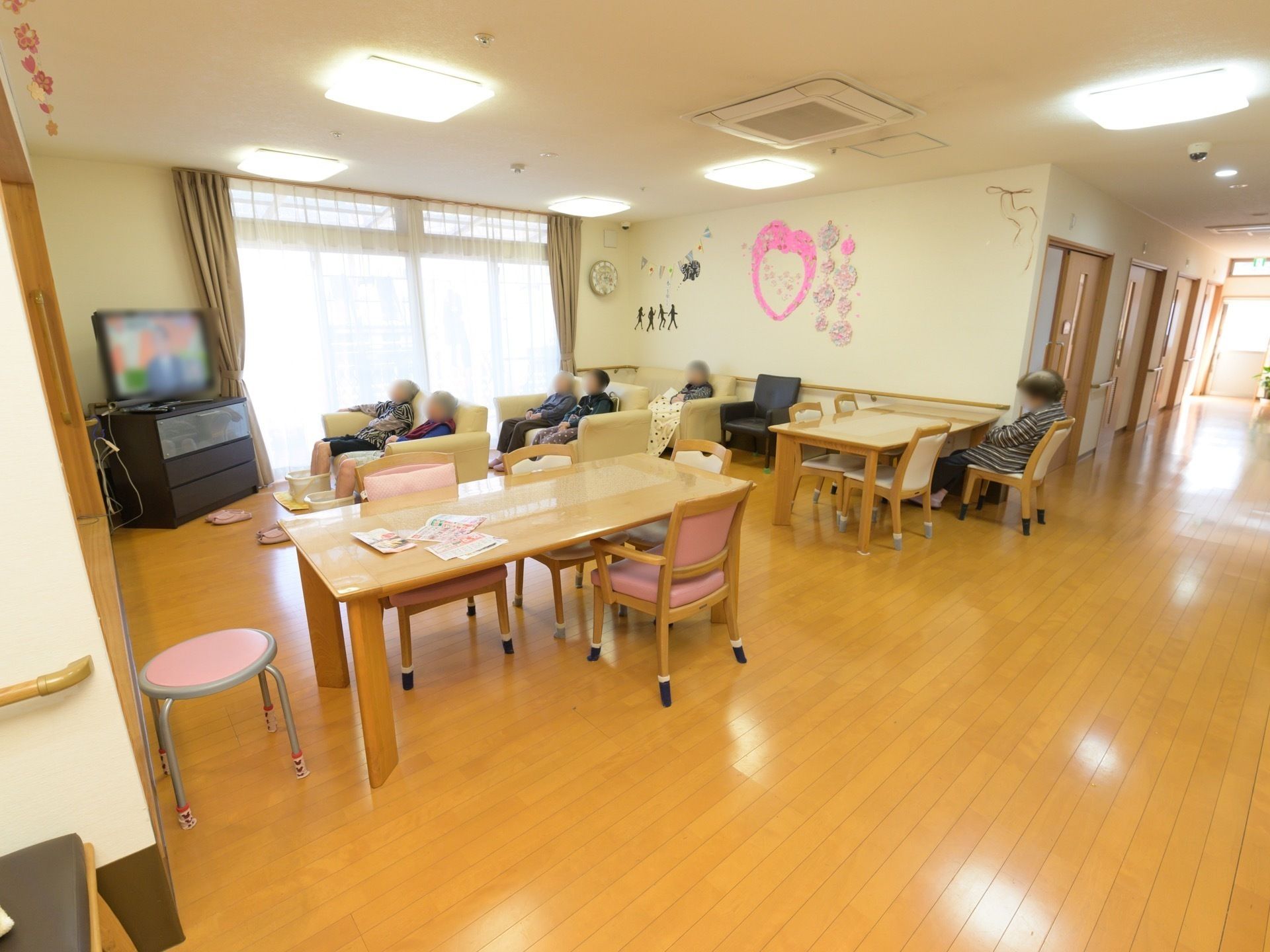 休憩スペースに置かれたソファに座って、テレビを見ている入居者様たち