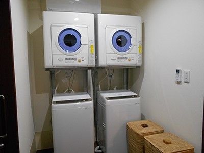 洗濯機と乾燥機のセットが２つ並べて置かれている洗濯室