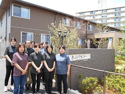 施設名称が表示されている看板の近くに集まっているスタッフ