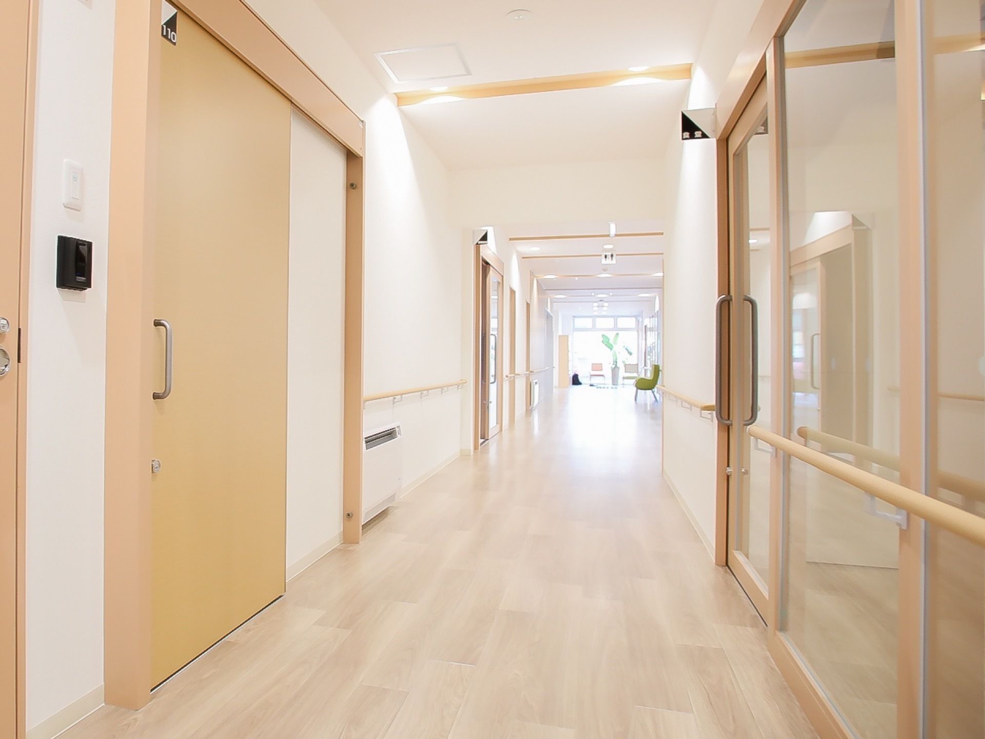 広くて明るい廊下である。各部屋の扉は、大きめの引き戸になっている。居室の入口にはインターホンが設置されている。