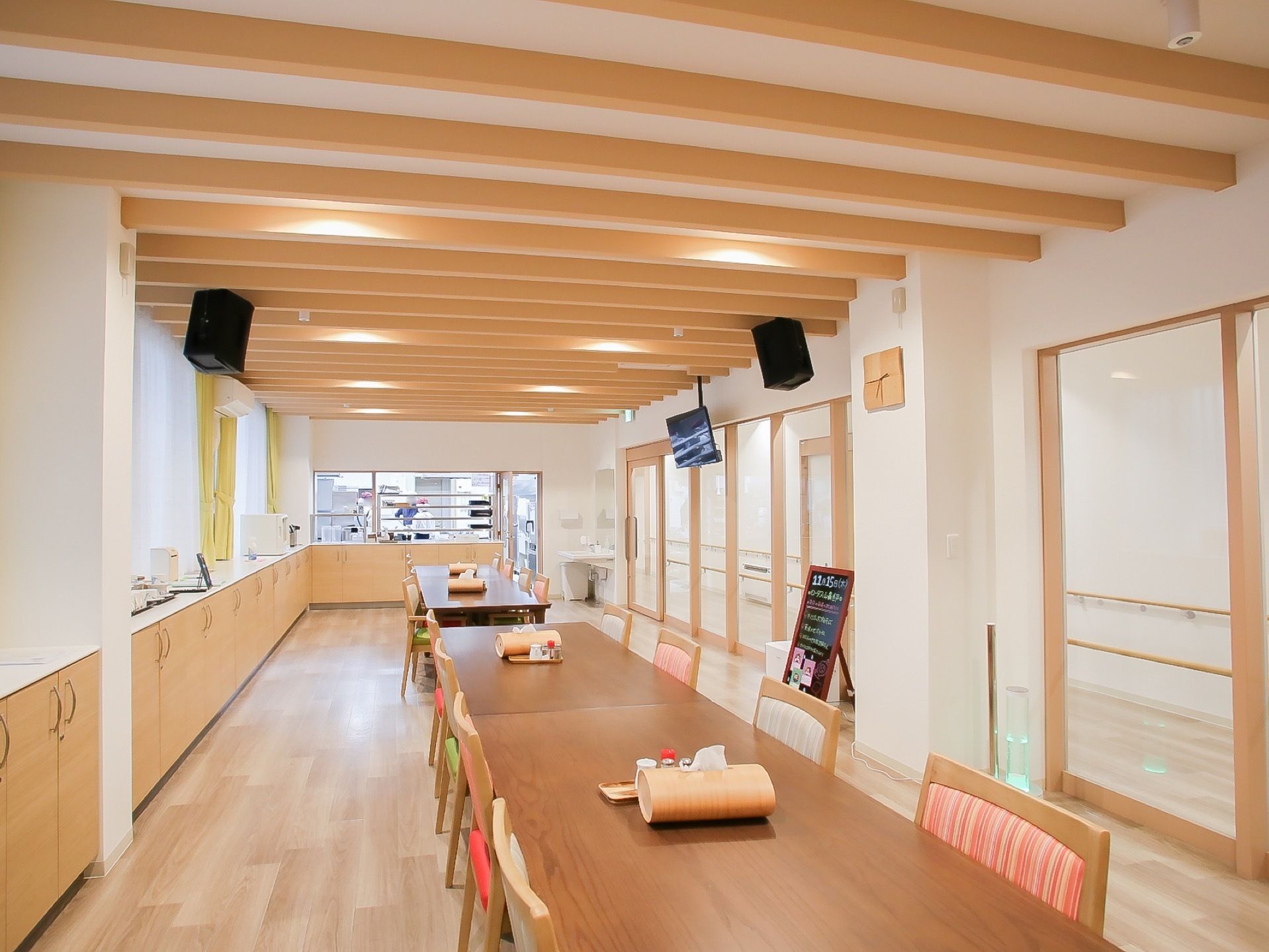 ナチュラルブラウンの建具で統一された、デザイン性のある食堂である。テーブルと椅子は縦長一列に配置されている。