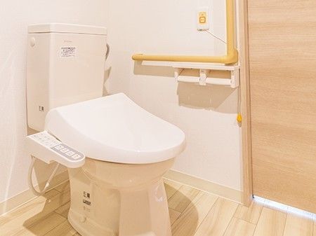 シャワー付きのトイレが設置された居室。手すりや呼び出しボタンもあり、安全に配慮した造り。