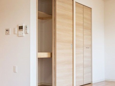 押し入れタイプの収納スペース。棚が付いていて整理しやすいデザイン。モニター付きインターホンもある。