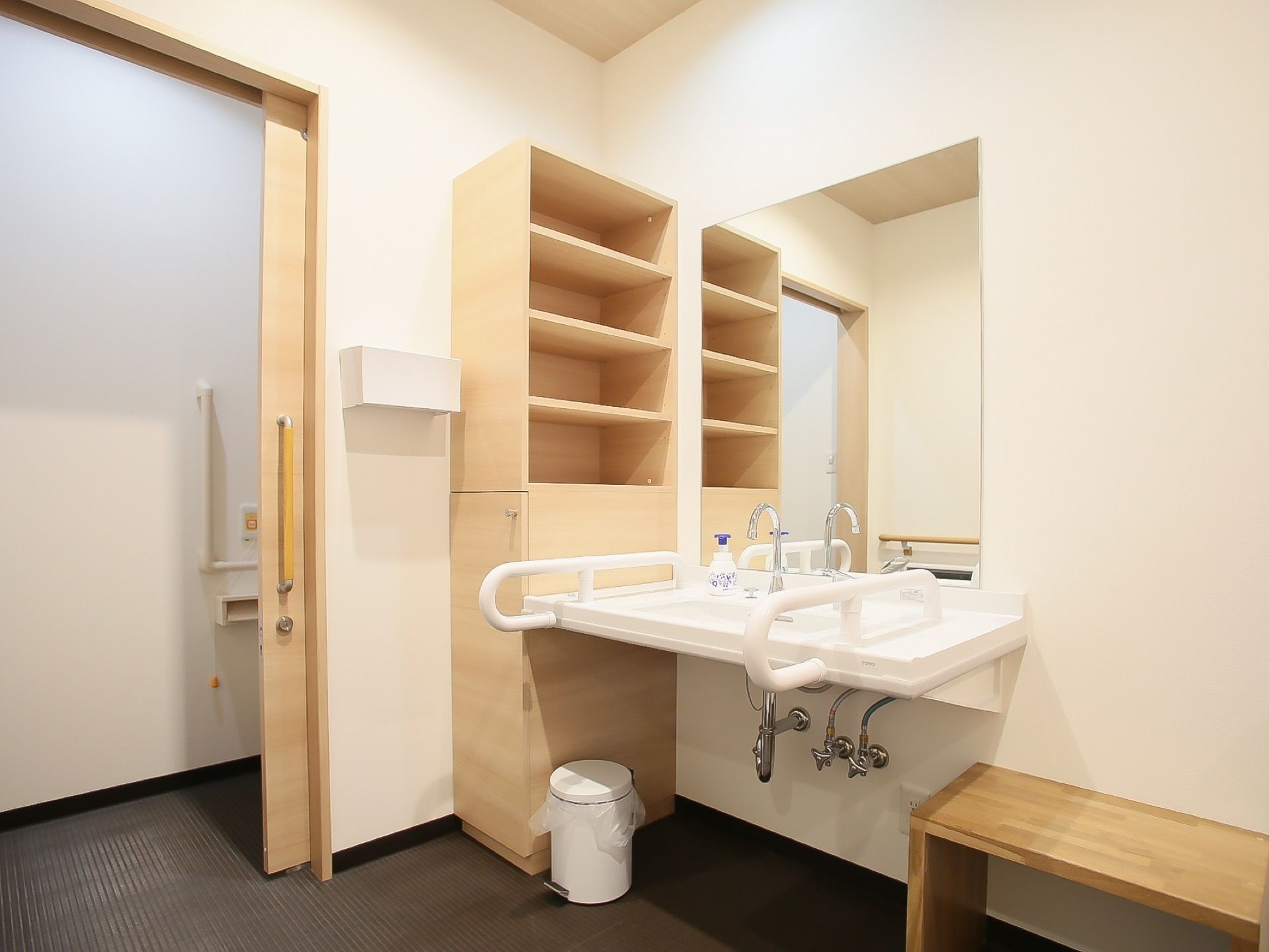 トイレの個室を出たところに洗面台が設置されている。洗面台に手すりが左右に設置されているので安全に利用することができる。