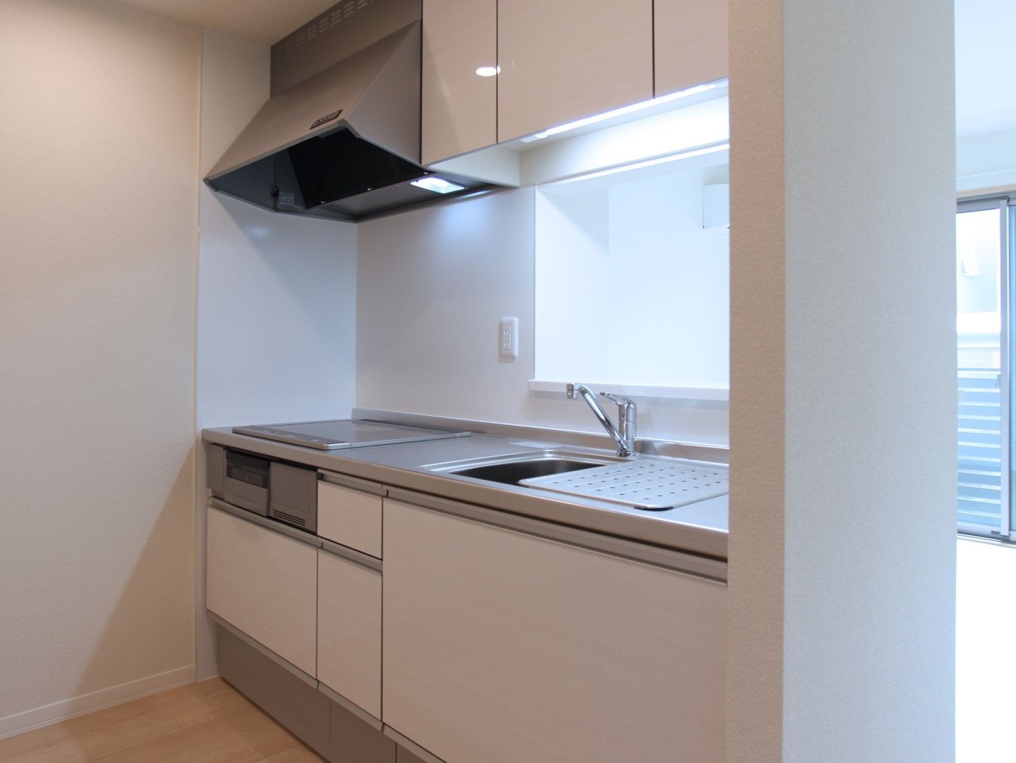 白を基調とした、シンク上に吊り棚のあるステムキッチン