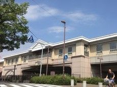 白を基調とした２階建ての大きな建物である。駅の目の前に大きな道路があり、横断歩道が設置されている。