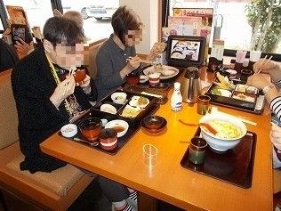 ４人がけのテーブルで、それぞれ別メニューの食事をしている人