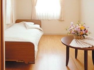 テーブルに花が置かれ、太陽の光が差し込む明るい居室