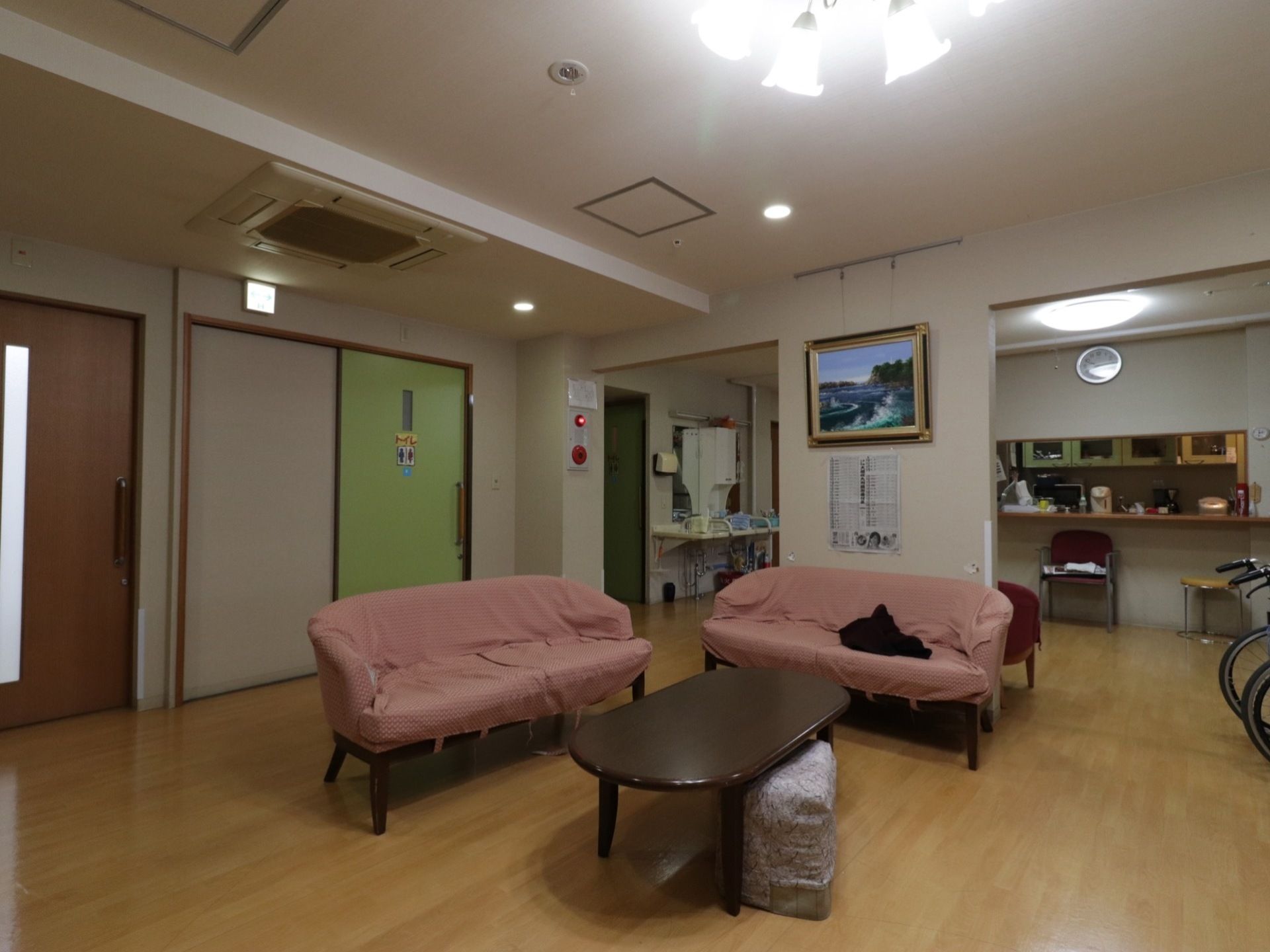 布製のカバーがかかったソファーがあり、アットホームな居間である。近くにはキッチンカウンターとトイレもある。