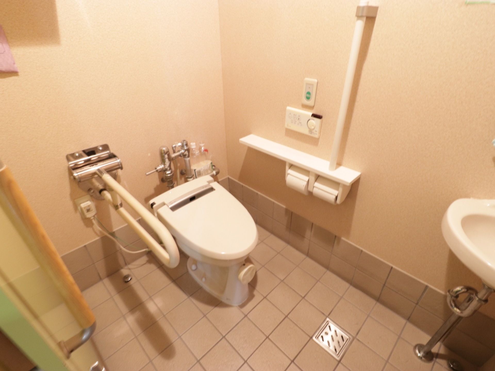 トイレの個室内には、洗面台がある。壁と便座脇に掴まることができるバーがあり、ナースコールもついている。