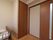 壁側にベッドが設置されている。収納は部屋に備え付けられている。扉は横に開き、縦に長い曇りガラスがついている。