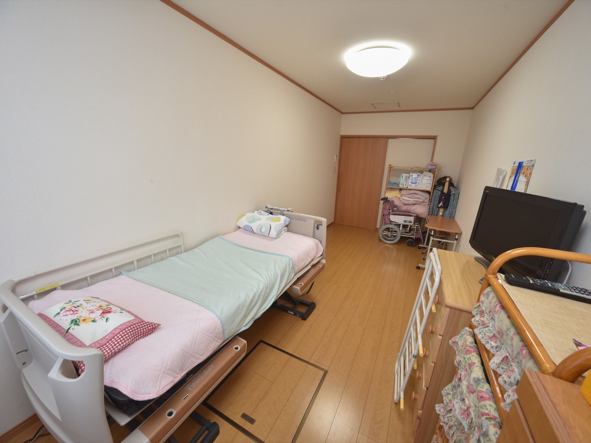 居室の床はフローリングで清潔感があり、タンス、テレビ、介護用ベッドがあるので、入居者様は不自由なく快適に過ごせる。