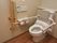 手すりと肘掛のあるトイレが設置されている。トイレ自体は家庭にあるものと変わらないので、違和感なく使用することが可能。
