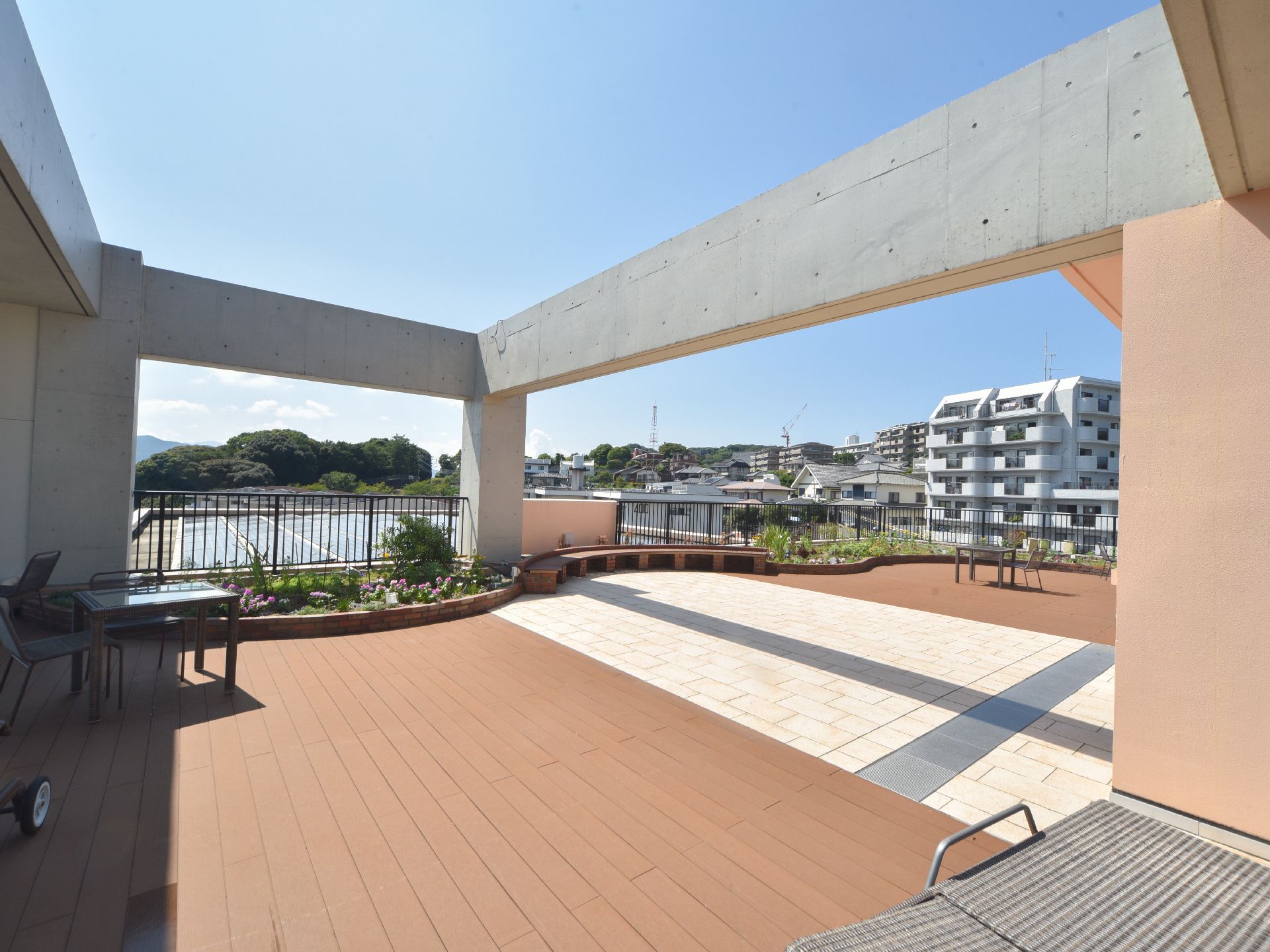 施設の屋上には、フェンスに沿って季節を彩る草花が植えられている。そして椅子とテーブル、造り付けの簡易ベンチが備え付けられている。
