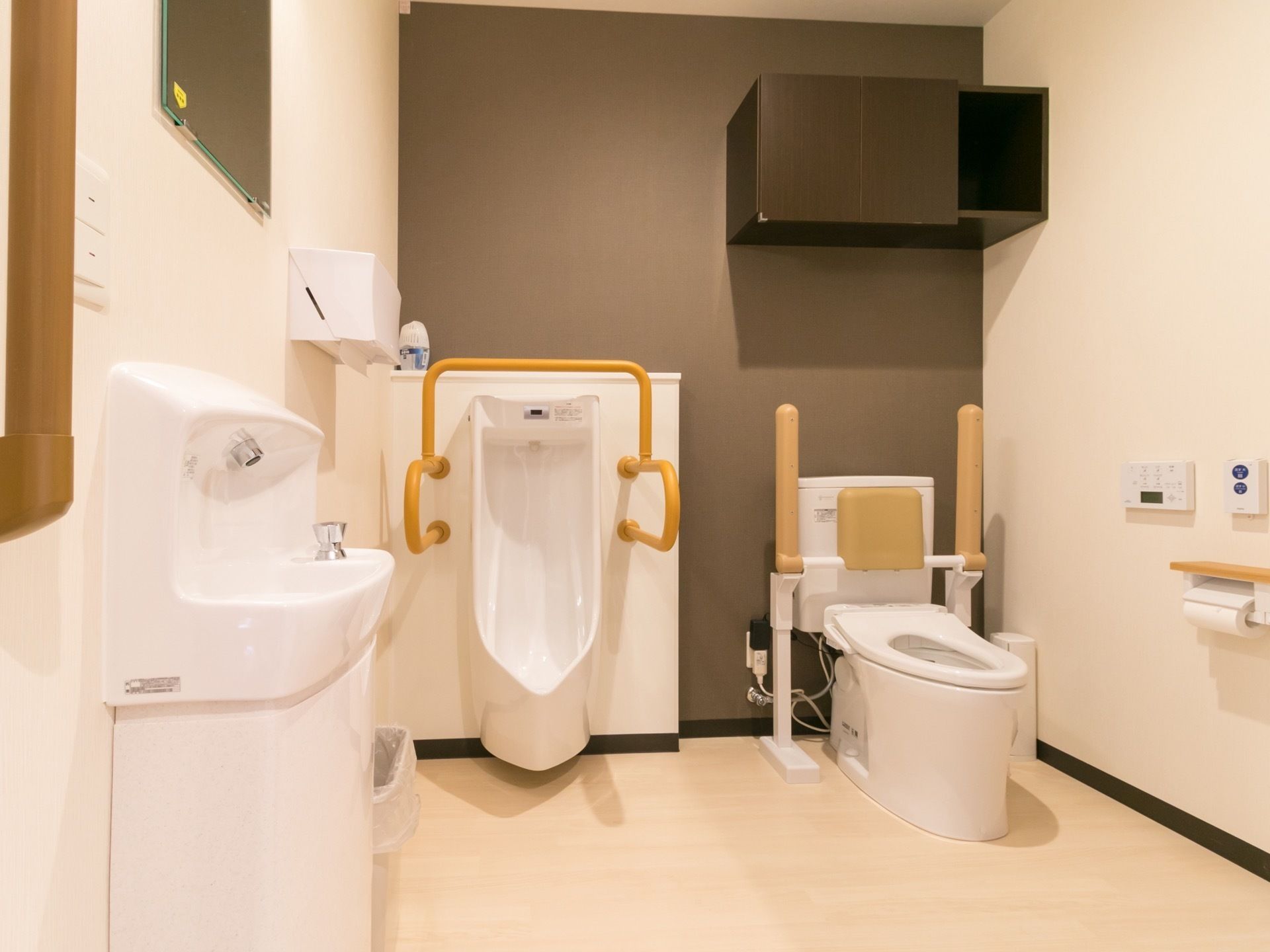 白とブラウン系の色でまとめられた落ち着いたデザインのトイレである。左端には、鏡付きの手洗い器が設置されている。