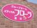 ピンク色の看板で施設名を表示している。白い文字で読みやすく、花のマークもあり明るい雰囲気になっている。