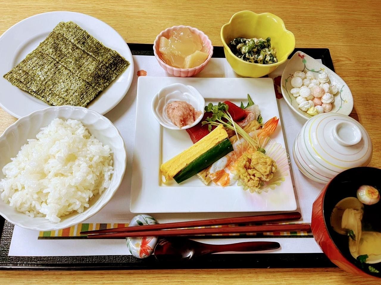 白色の四角いプレートの上に、生ハムやトマトを使った料理が美しく盛り付けられている様子