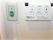 温水洗浄機能付きトイレの操作パネルが白い壁に設置されている。その左側には紐のついた呼び出しボタンが取り付けられている。