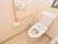 温水洗浄便座付きトイレである。壁に手すりと操作パネルが取り付けられている。呼び出しボタンが設置してある。