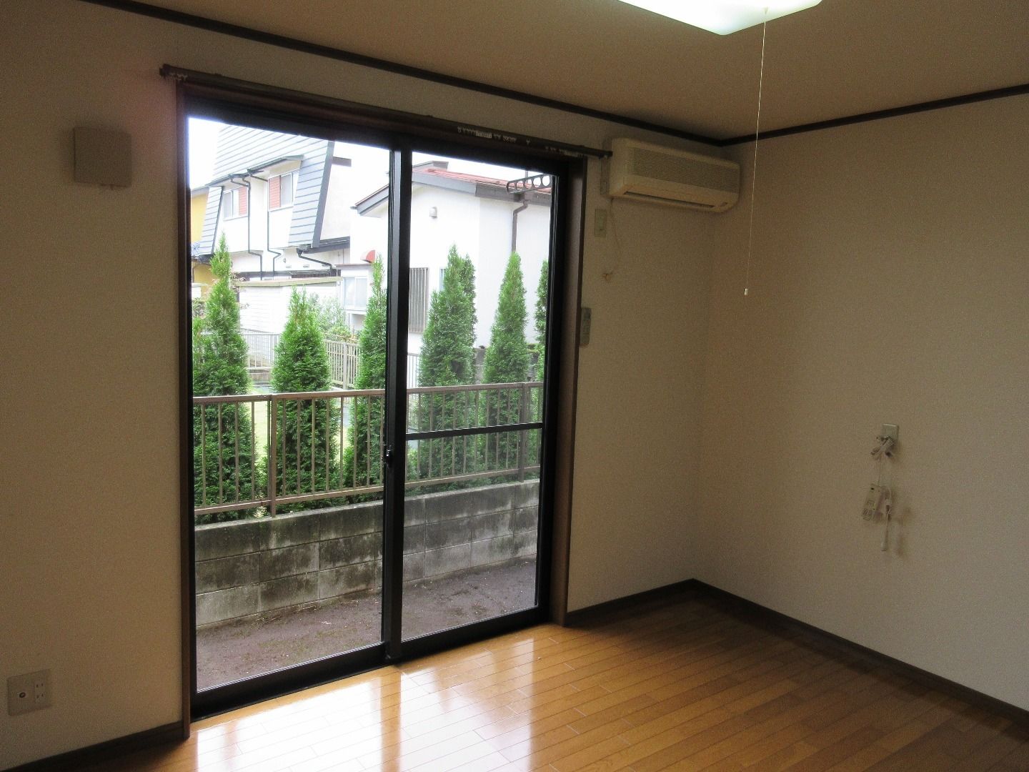 居室には日当たりの良い大きな窓がある。窓の向こうには塀に沿って木が植わっており、プライベートが守られている。