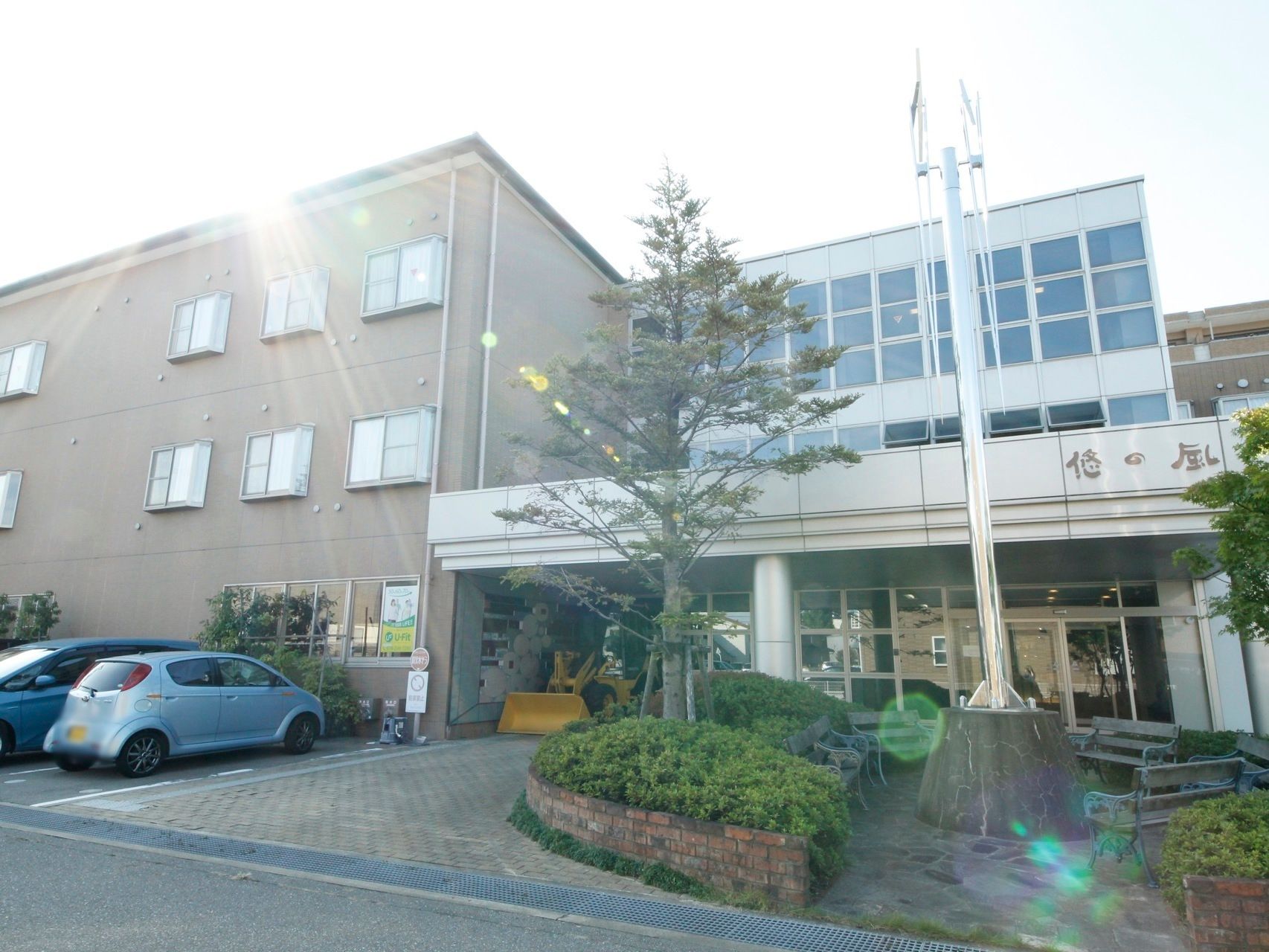 施設の敷地内には、駐車場が整備され、そのすぐそばにベンチが置いてある。日かげができるほどの木々があり、利用者様が和むことができる。