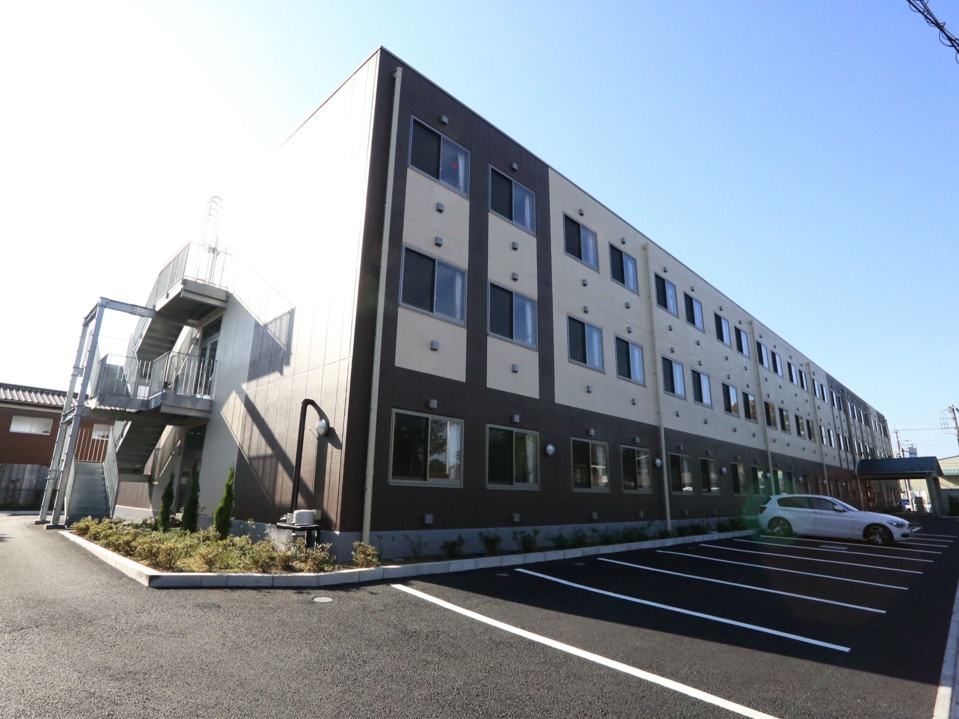 施設はブラウン系でデザインされた三階建ての建物である。前面にはアスファルト舗装の広い駐車場を完備している。