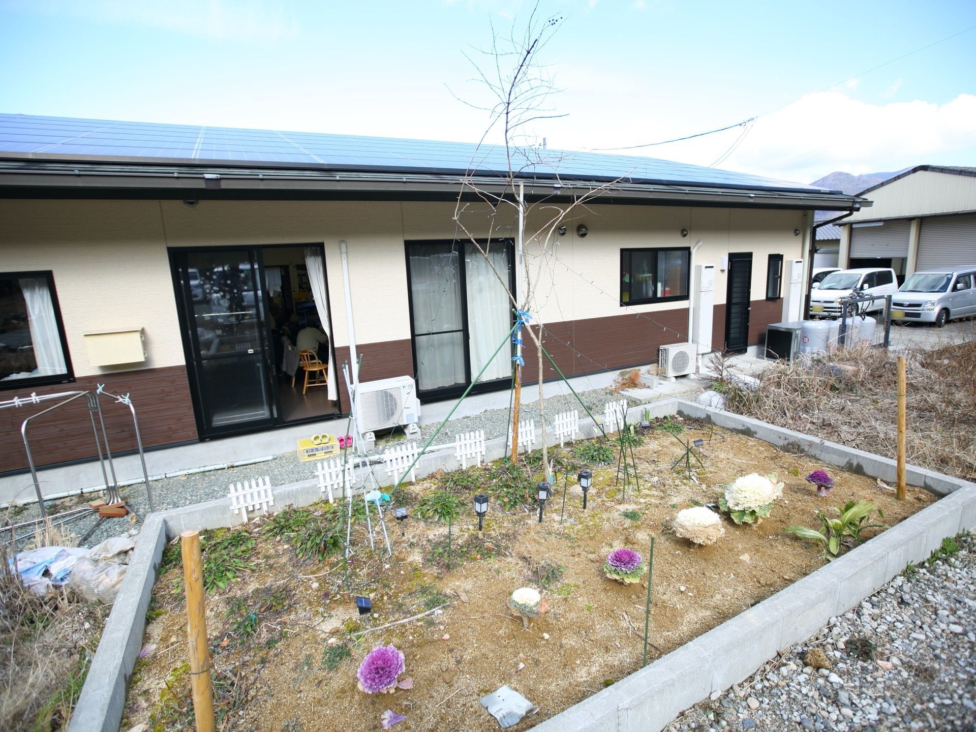 施設の建物の周りには駐車場や花壇などがある。花壇では葉牡丹などを育てている。布団干しなども行っている。