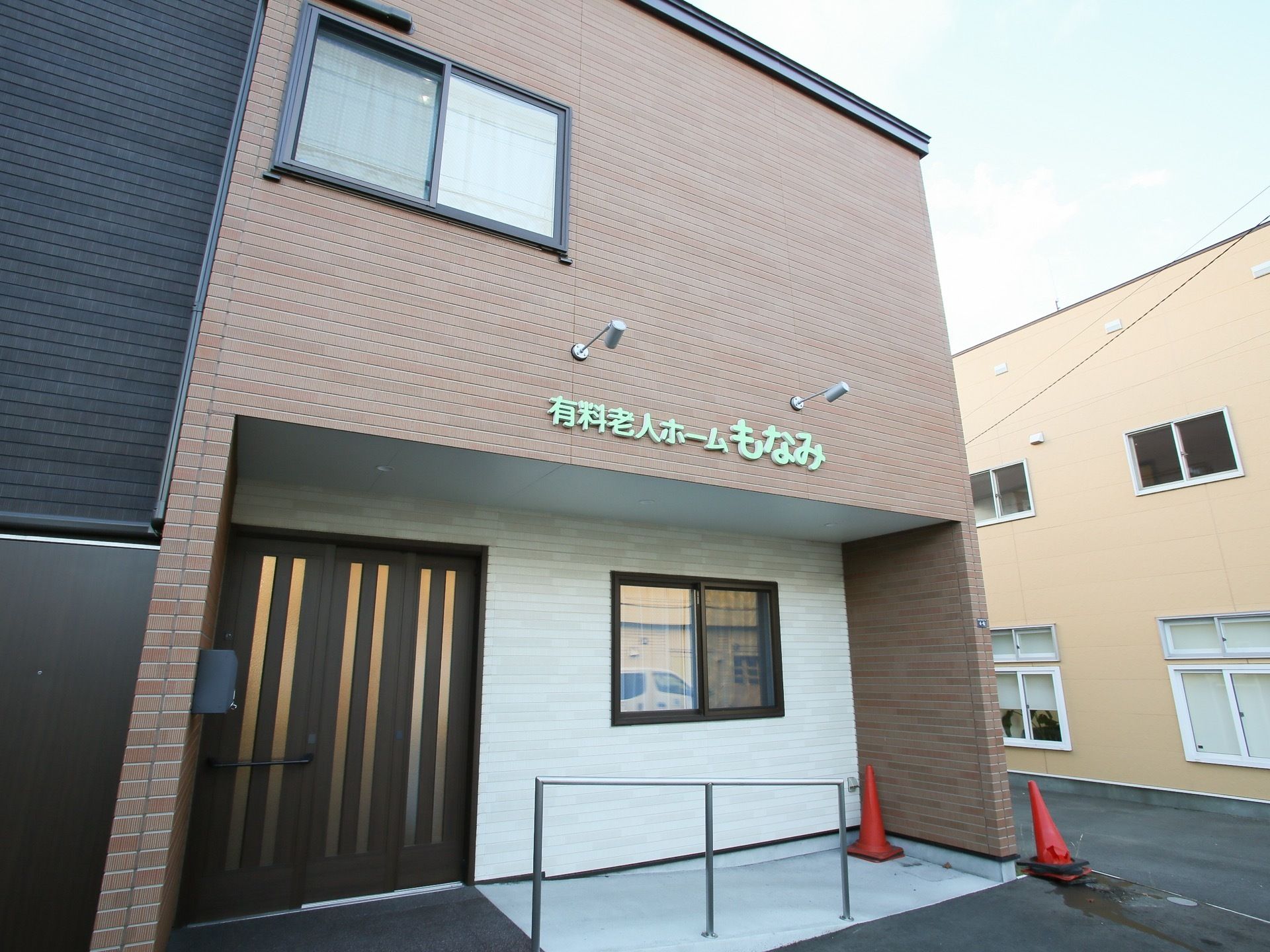 レンガ調の建物になっており、玄関の上の壁には施設名が書かれている。玄関のドアは茶色の引き戸になっており、手すりがついている。