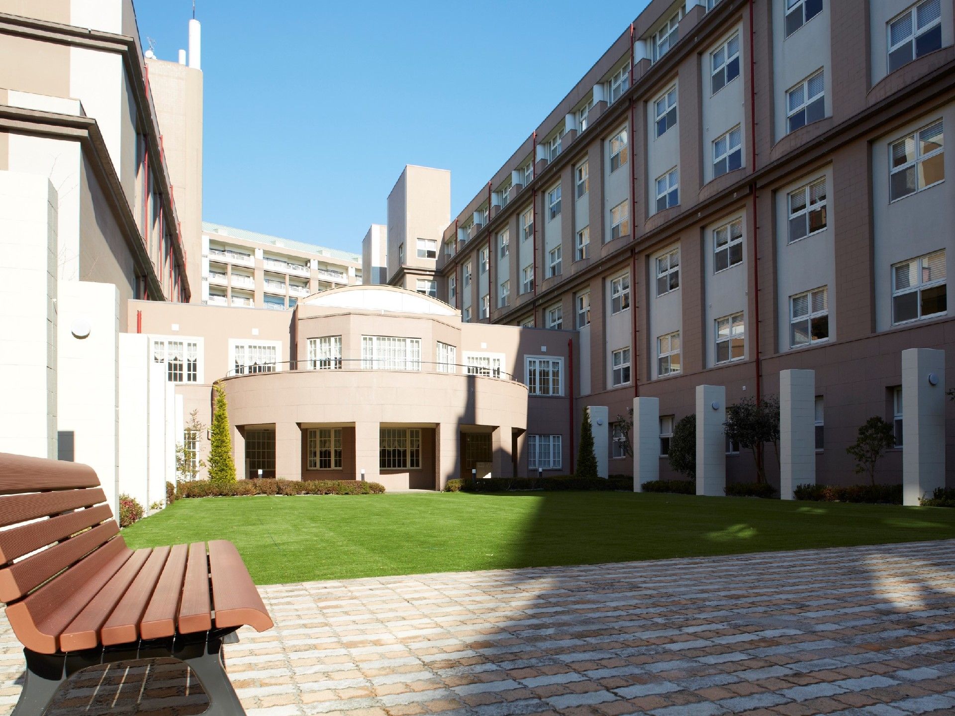 鮮やかな緑色の芝生が植えられている、施設の中央にある中庭