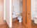 居室の入口の近くに開き戸があり、その中にトイレがある。手すりやひじ掛けがついている。その横には、洗面台が設置されている。