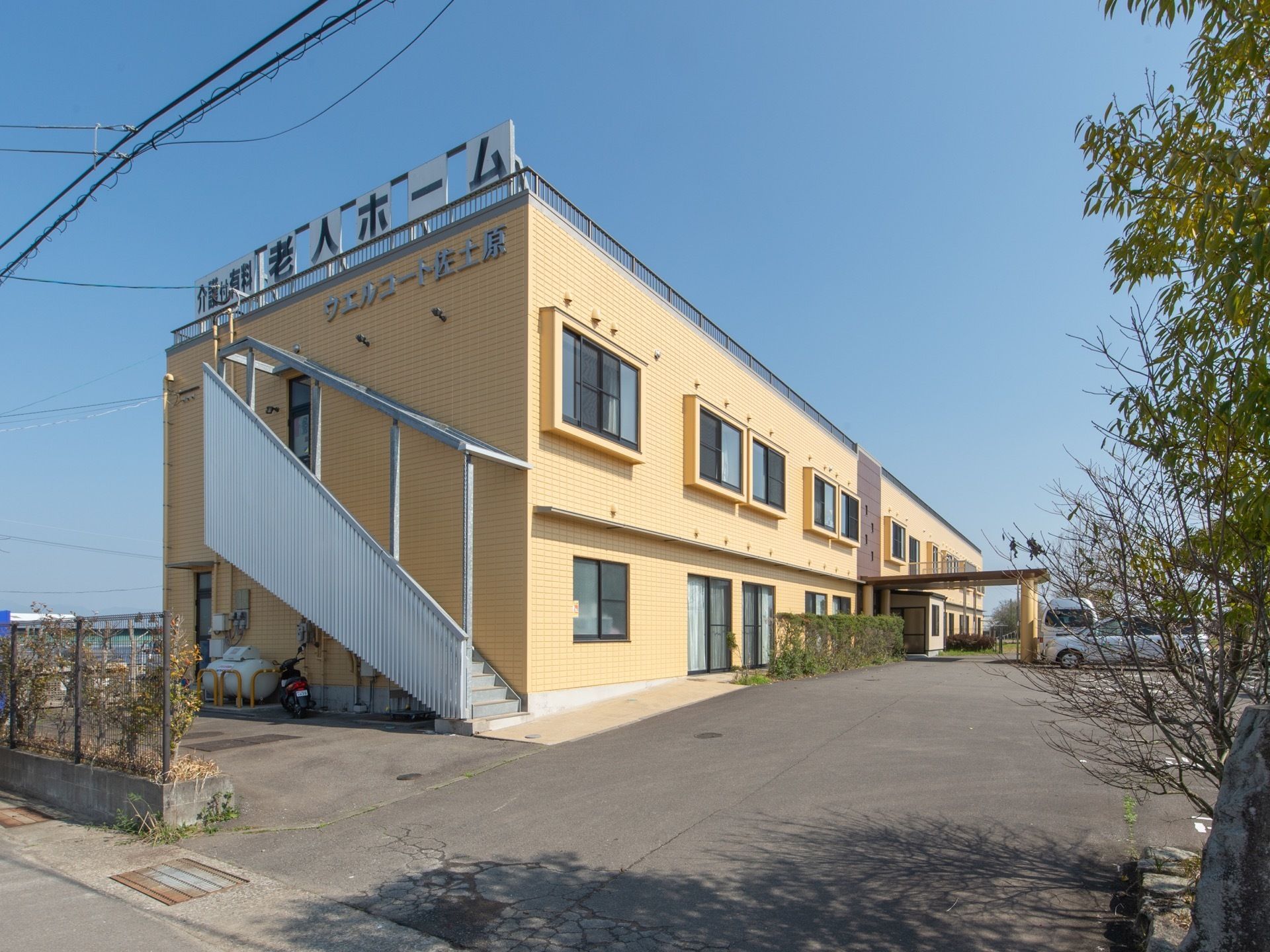 黄色い外壁の地上2階建ての施設となっている。建物の横には階段が取り付けられている。屋上には看板が設置されている。