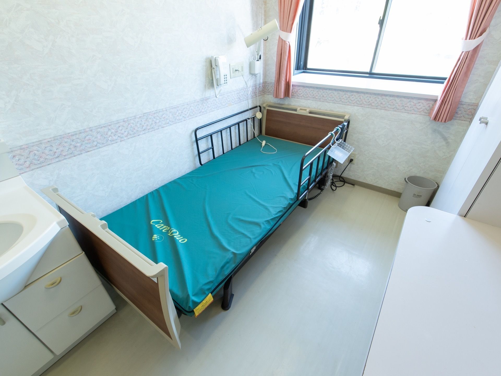 居室内には介護用電動ベッド、洗面台、クローゼットなどが完備されている。腰高窓があり、外からの光がさしこみ明るい雰囲気である。