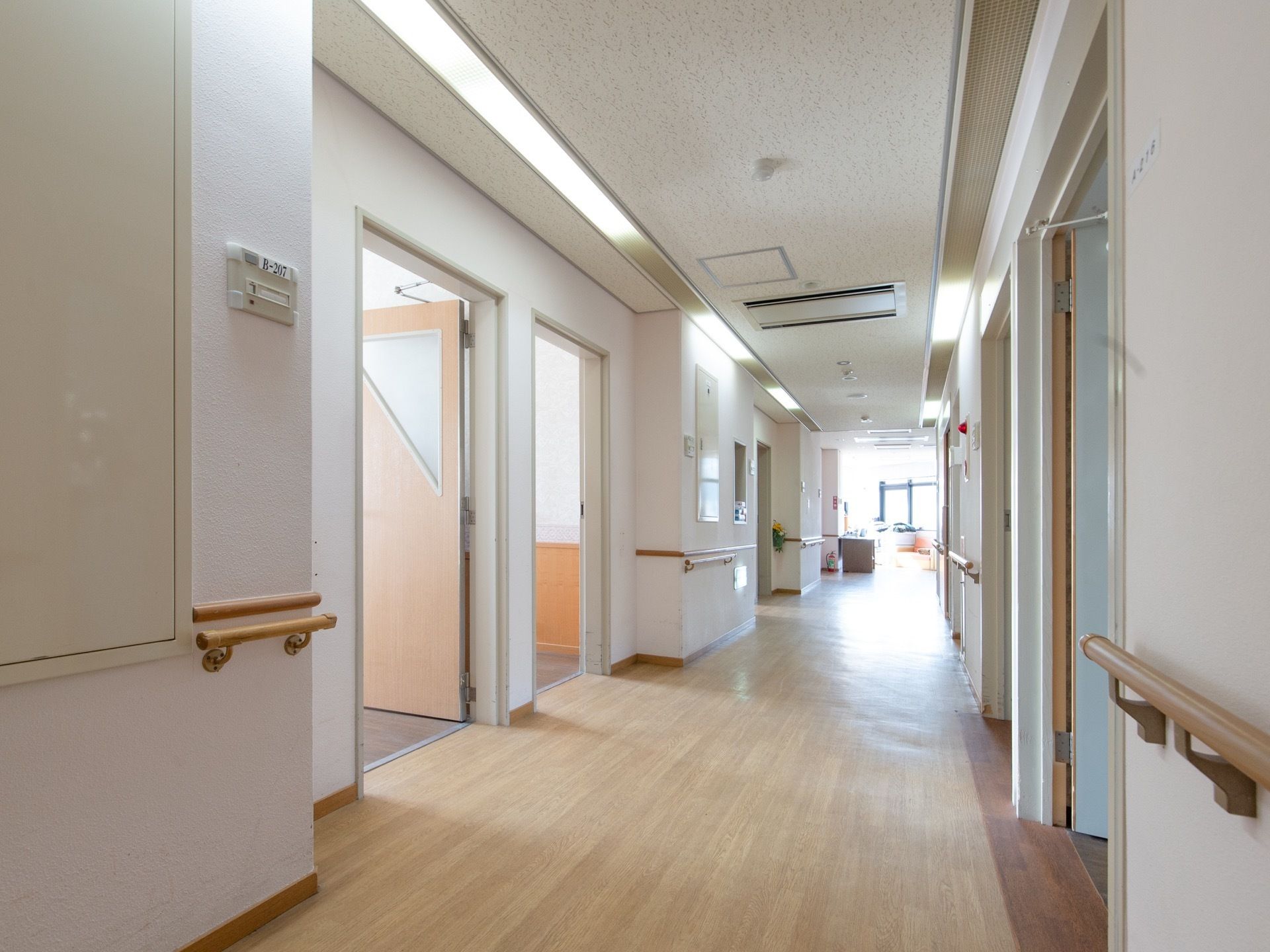 通路の両側には各居室が配置され、壁には手すりが取りつけてある。施設内は段差のないバリアフリーの造りである。